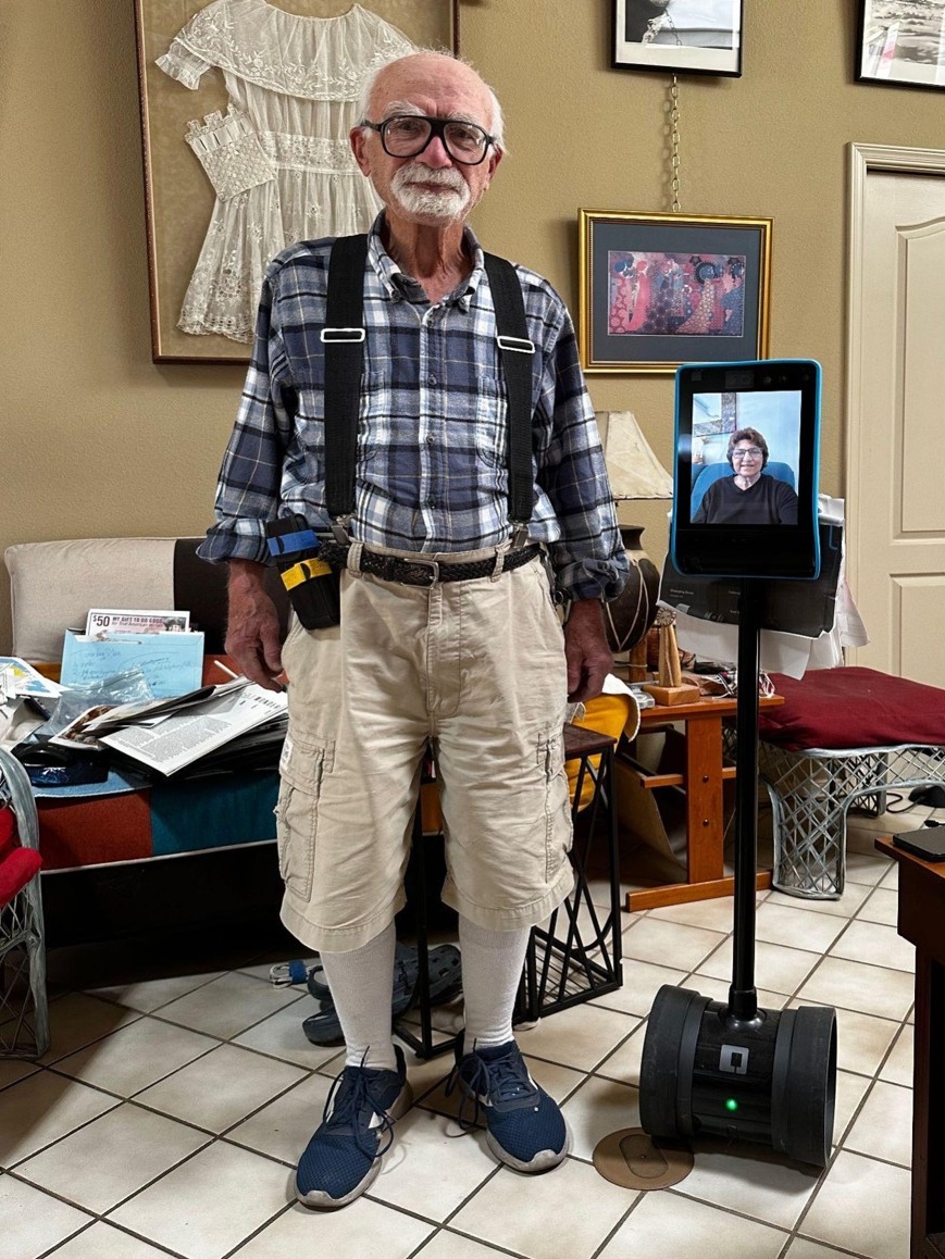 Marlena, a nonbinary person with deep pink, purple, and green hair and green eyeshadow, wearing a green and black striped dress, staring fiercely into the camera